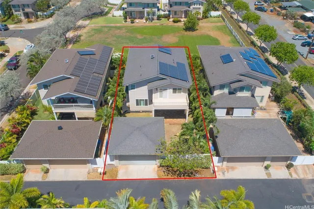 an aerial view of a city with lots of residential buildings and ocean view in back