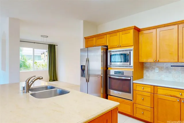 a kitchen with stainless steel appliances granite countertop a sink and a refrigerator