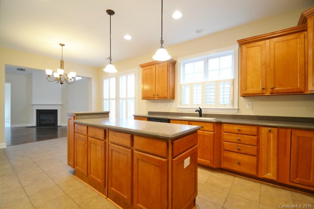 9433 Ridgeforest Drive Charlotte, NC 28277 - Photo 6 of 18 a kitchen with stainless steel appliances granite countertop wooden cabinets a stove a sink and a large window