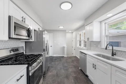 a kitchen with stainless steel appliances a sink stove and microwave