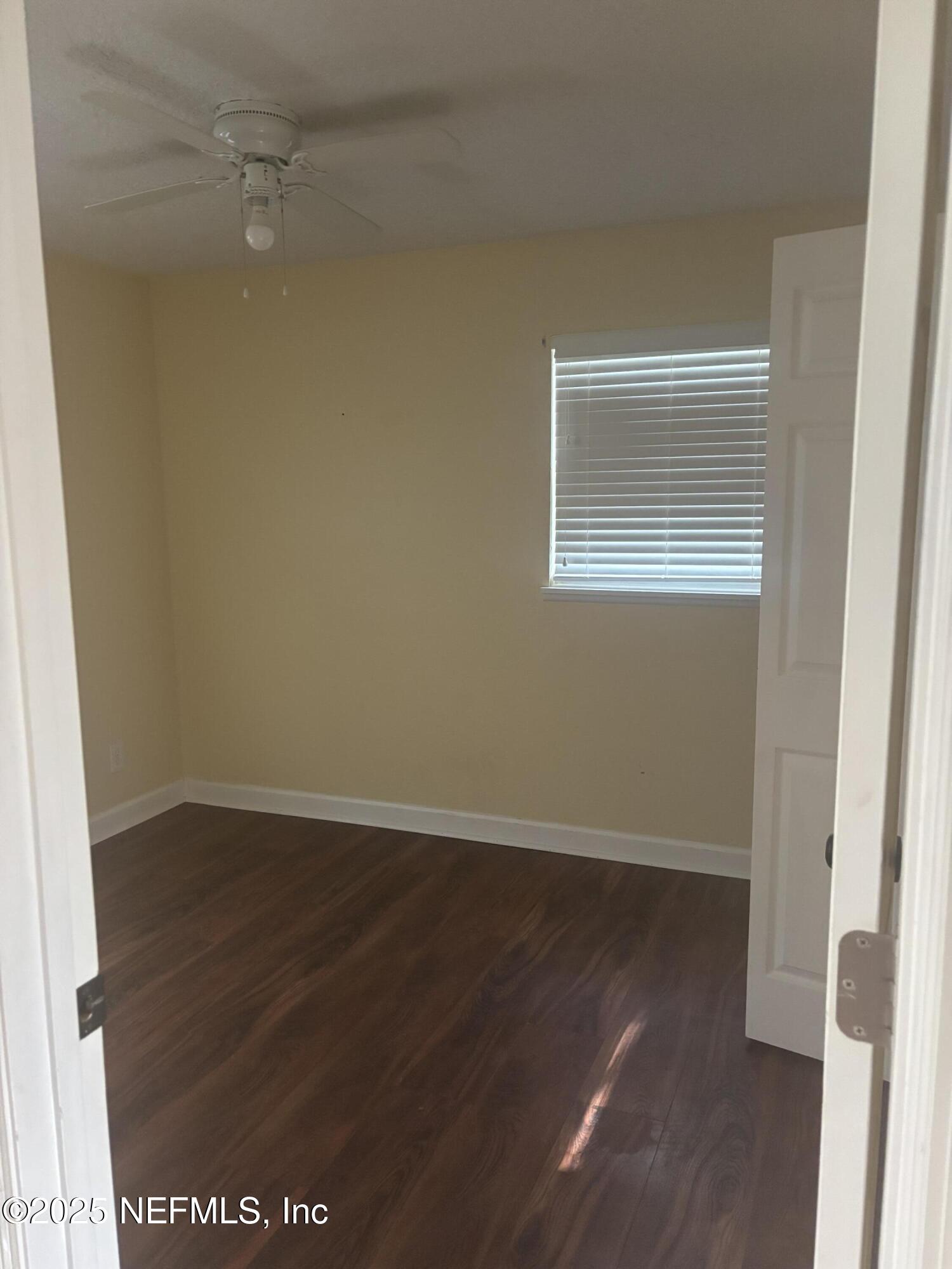 428 Neptune Road Orange Park, FL 32073 - Photo 6 of 14 an empty room with wooden floor and windows