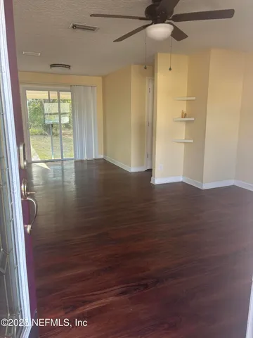 a view of an empty room with wooden floor