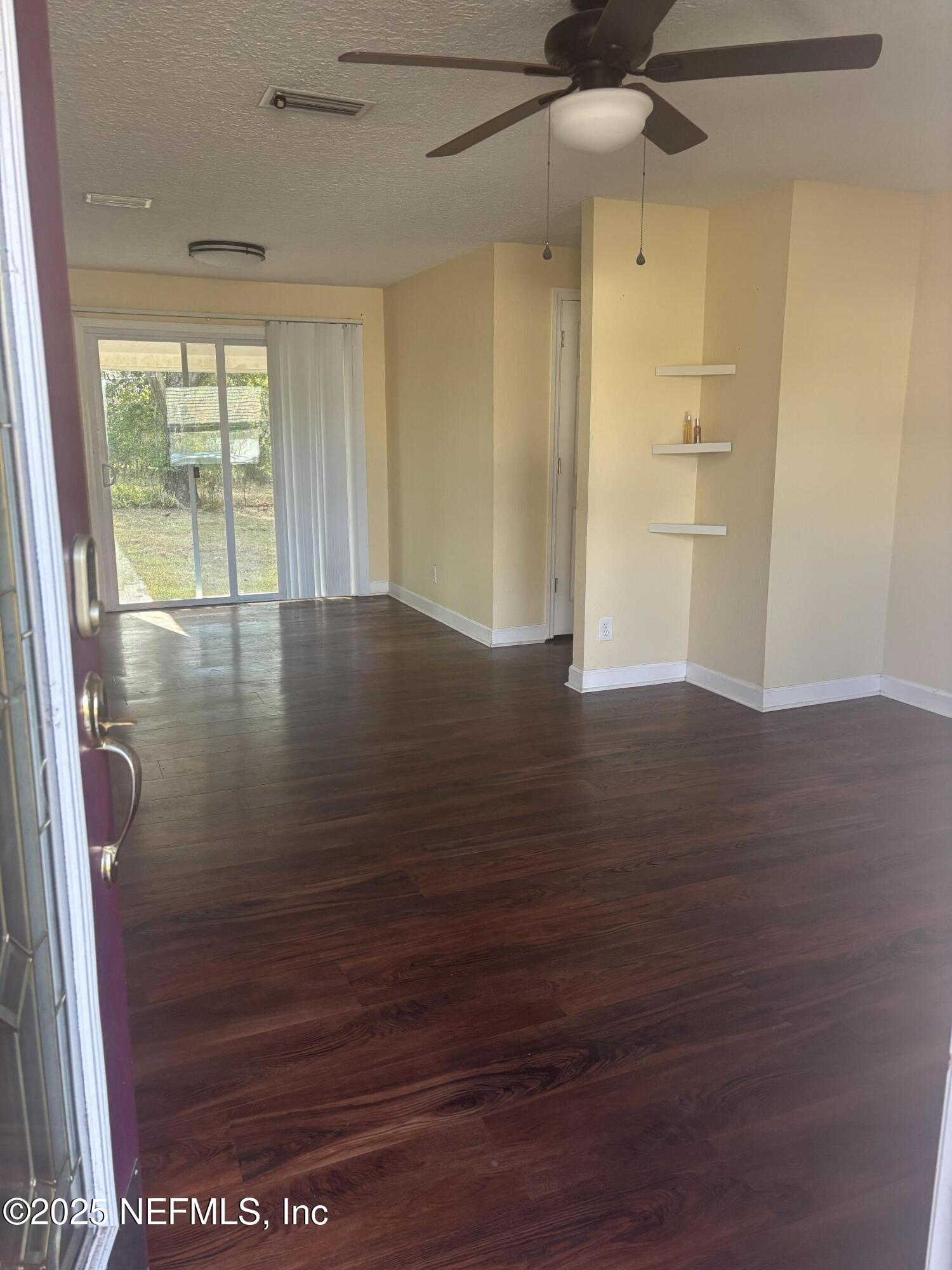 428 Neptune Road Orange Park, FL 32073 - Photo 7 of 14 a view of an empty room with wooden floor and a window