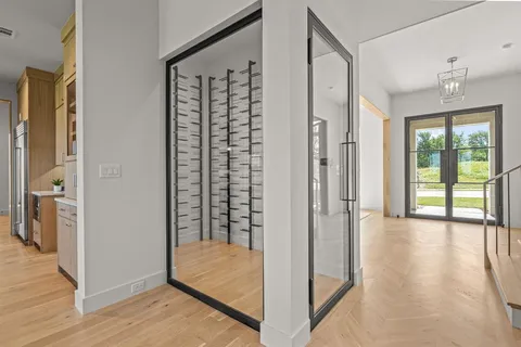 a view of a hallway with wooden floor and livingroom with furniture