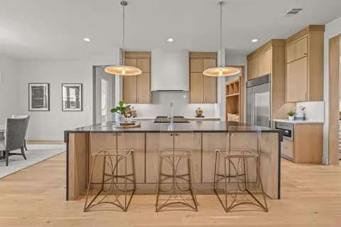 a dining room filled chandelier and wooden floor