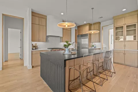 a kitchen with stainless steel appliances granite countertop a stove a sink and a refrigerator