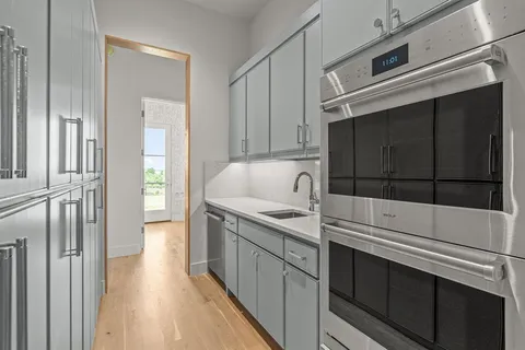 a kitchen with granite countertop white cabinets and stainless steel appliances