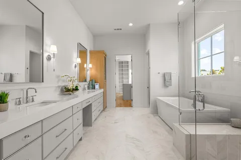 a spacious bathroom with a double vanity sink a mirror and a bathtub
