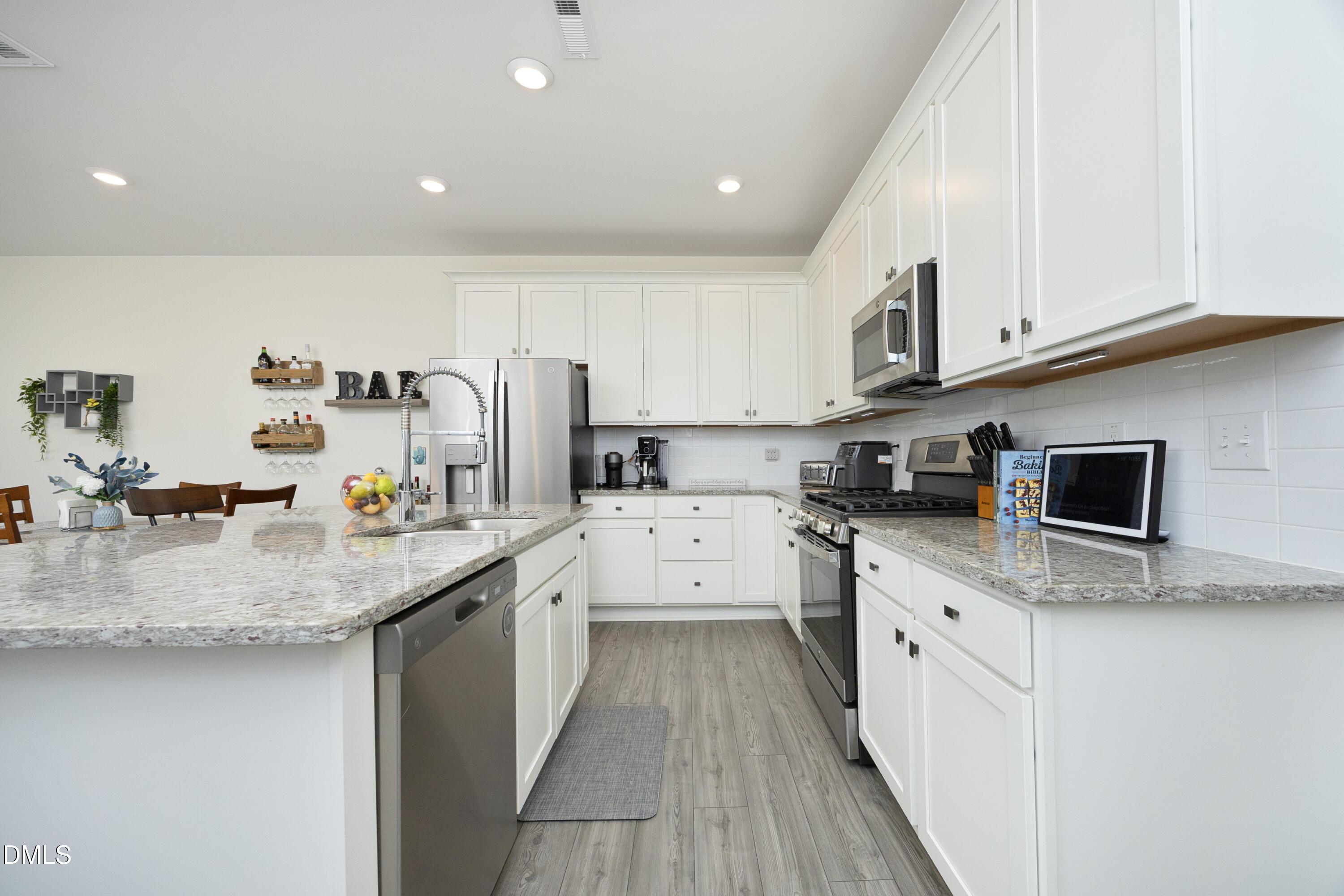 1002 Heartstone Way Durham, NC 27713 - Photo 2 of 35 a kitchen with stainless steel appliances granite countertop a sink a stove and cabinets