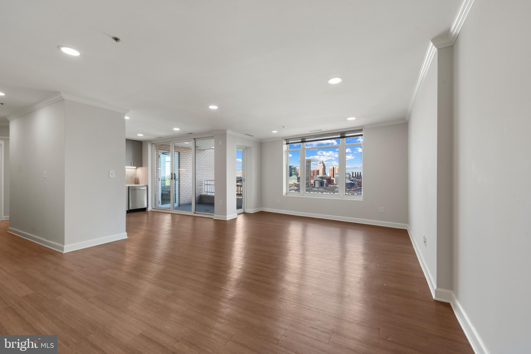 100 Harborview Drive, Unit 1209 Baltimore, MD 21230 - Photo 34 of 43 a view of an empty room with a window and wooden floor
