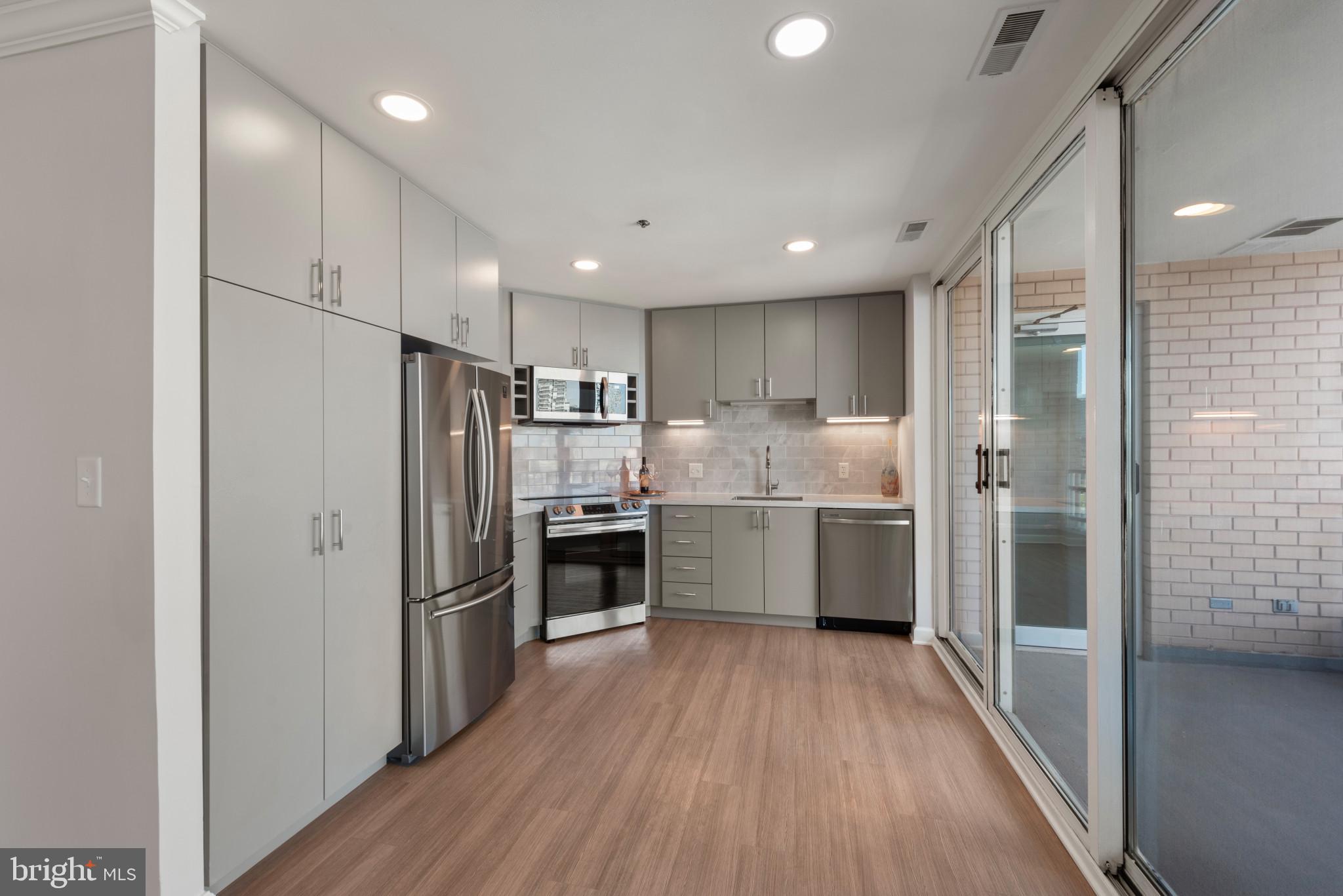 100 Harborview Drive, Unit 1209 Baltimore, MD 21230 - Photo 5 of 43 a kitchen with refrigerator a stove top oven and wooden floor
