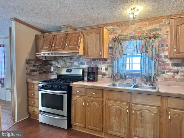 a kitchen with cabinets appliances a sink and a window