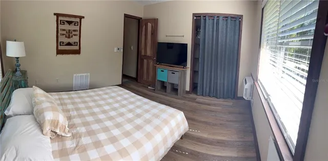 a bedroom with a bed closet and a large window