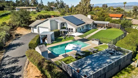 a view of a swimming pool with a yard and plants