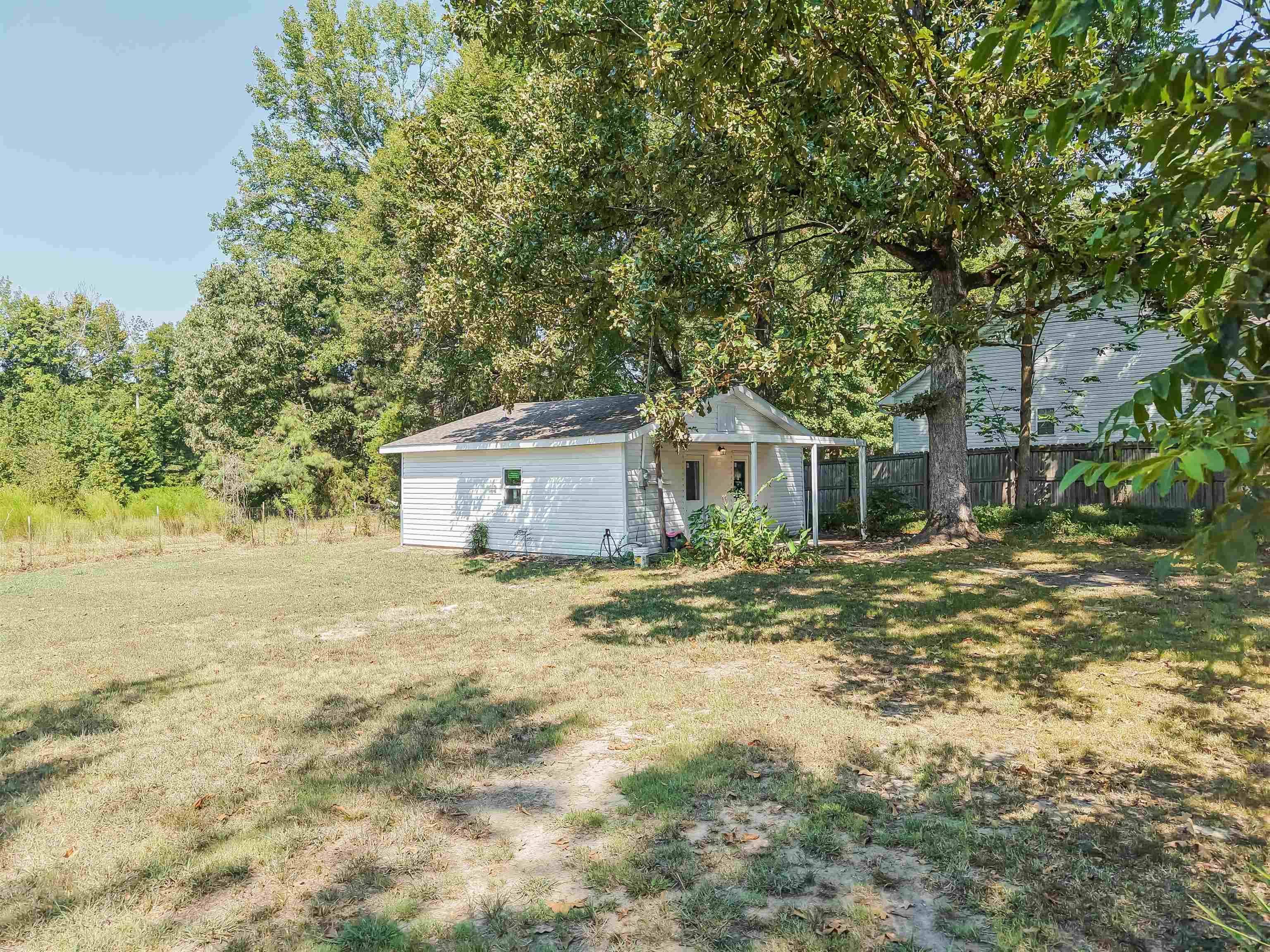 7437 Highway 45 Ramer, TN 38367 - Photo 7 of 36 Expansive outdoor space with mature trees, a covered entry, and a secondary structure with vinyl siding