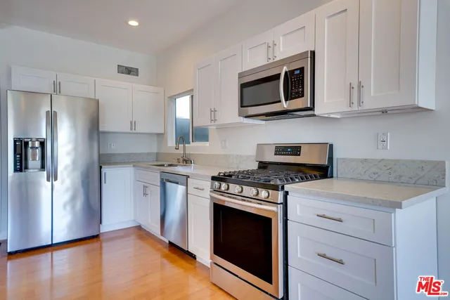 a kitchen with stainless steel appliances granite countertop a stove a refrigerator and a microwave