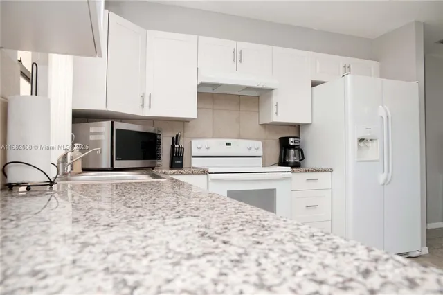 a kitchen with a stove a refrigerator and a sink
