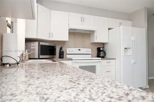 a kitchen with a stove a refrigerator and a sink
