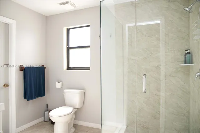 a bathroom with a toilet and a shower