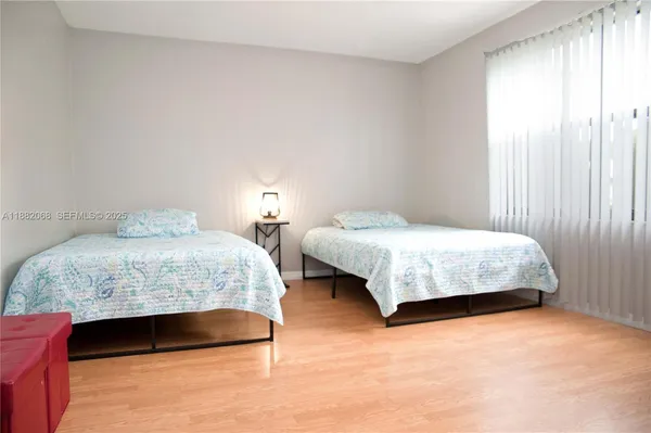 a bedroom with two beds and a window