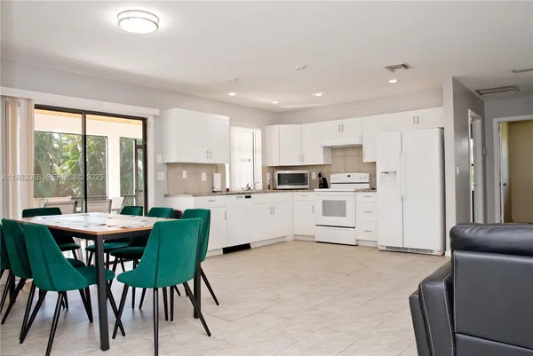 a kitchen with white cabinets and refrigerator