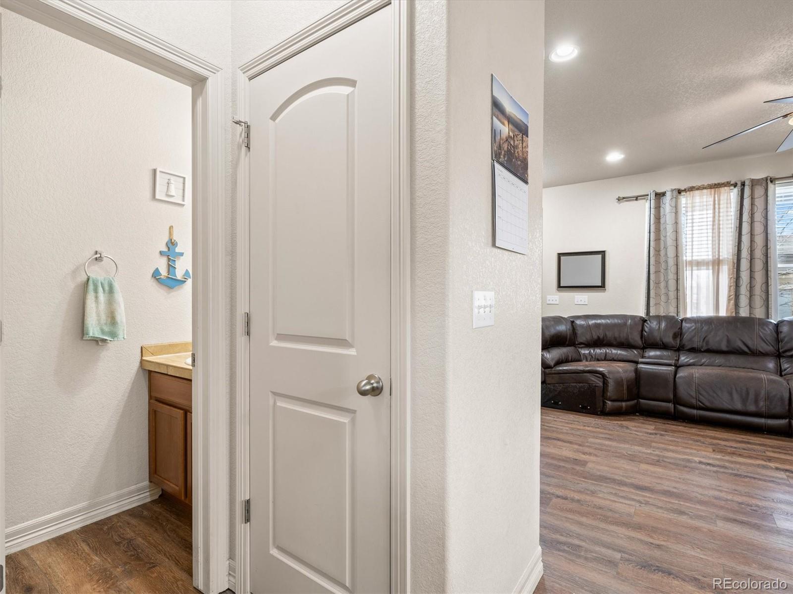 1940 Basil Street Strasburg, CO 80136 - Photo 16 of 38 a living room with furniture and a wooden floor
