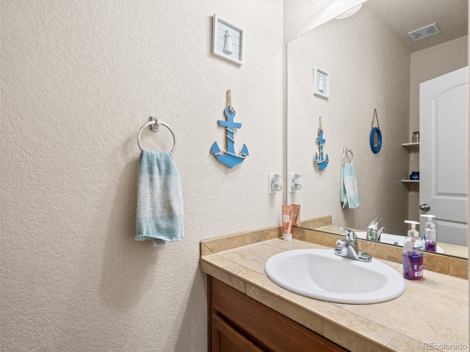 1940 Basil Street Strasburg, CO 80136 - Photo 17 of 38 a bathroom with a sink vanity and a mirror