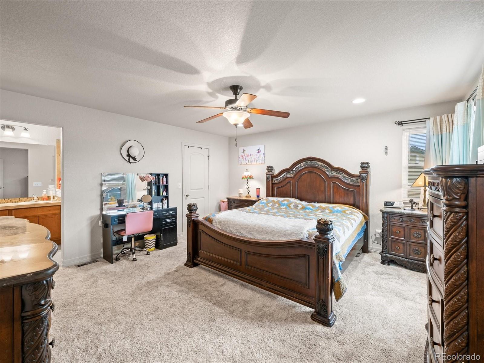 1940 Basil Street Strasburg, CO 80136 - Photo 18 of 38 a bedroom with a bed and a chandelier