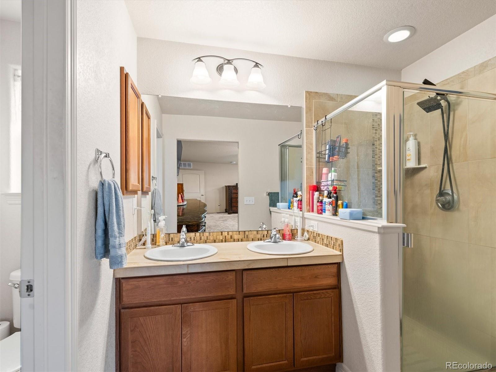 1940 Basil Street Strasburg, CO 80136 - Photo 21 of 38 a bathroom with a sink vanity and mirror