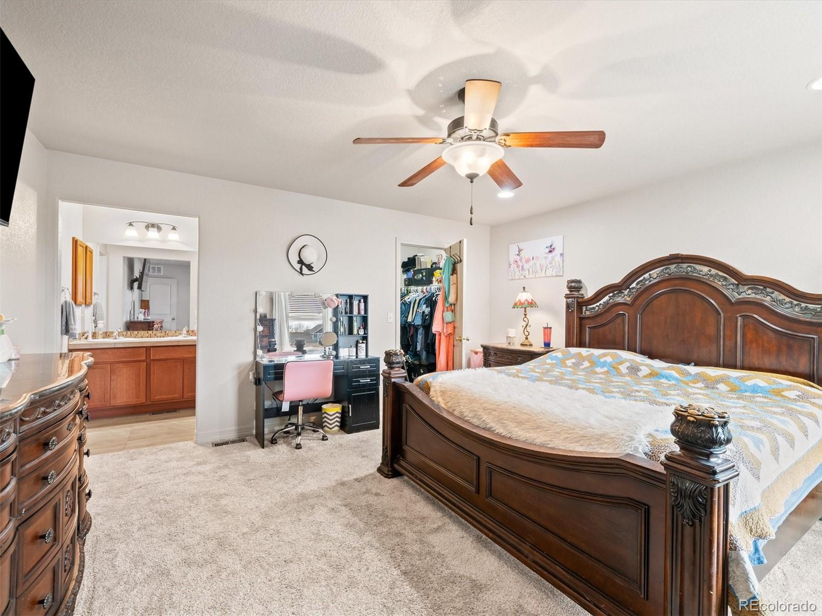 1940 Basil Street Strasburg, CO 80136 - Photo 22 of 38 a bedroom with a bed and a chandelier
