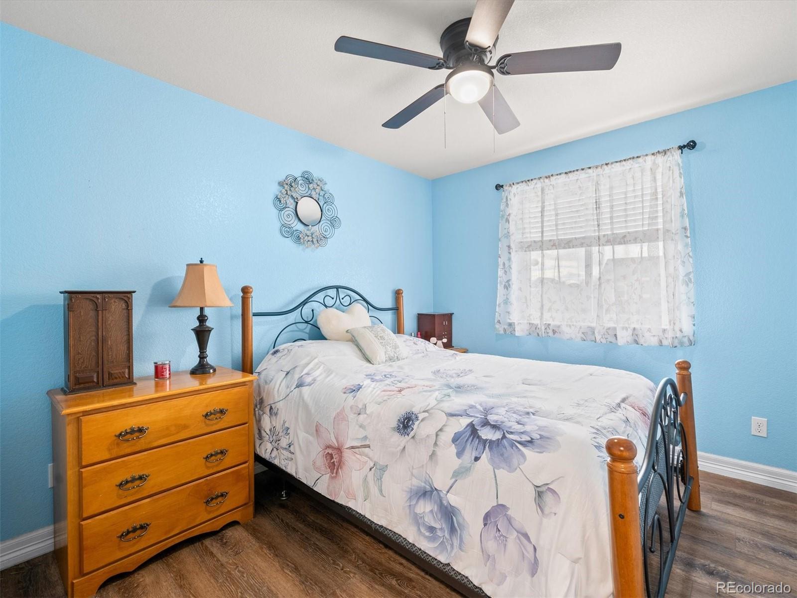 1940 Basil Street Strasburg, CO 80136 - Photo 23 of 38 a bedroom with a bed and a chandelier