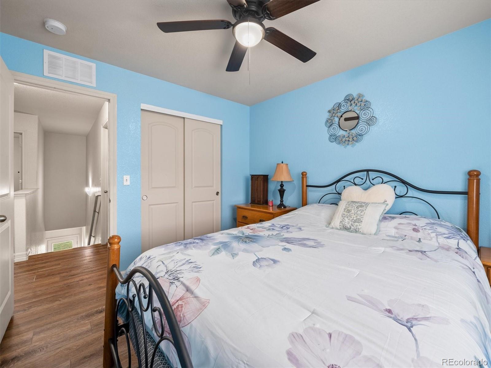1940 Basil Street Strasburg, CO 80136 - Photo 24 of 38 a bedroom with a bed and wooden floor
