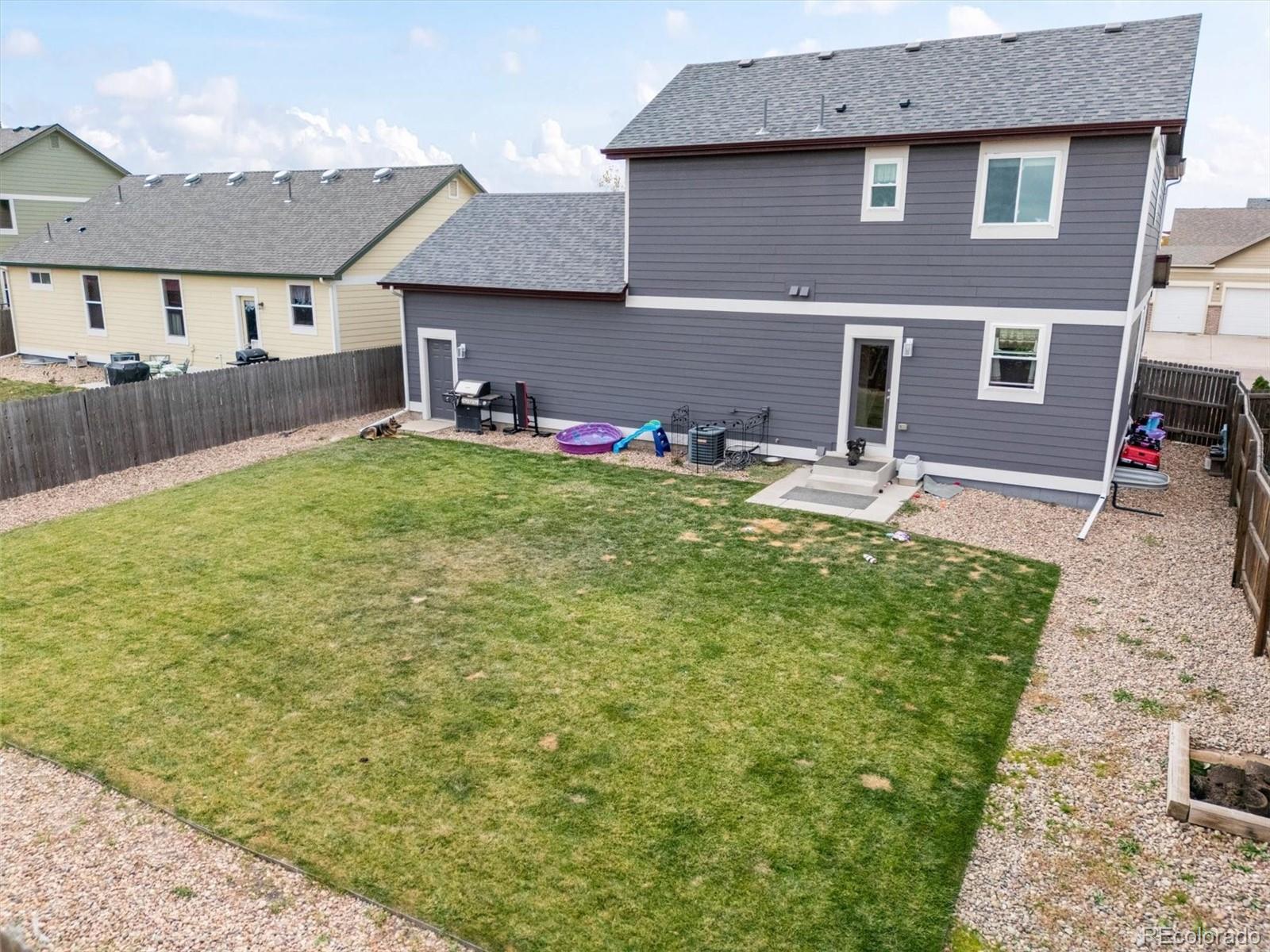 1940 Basil Street Strasburg, CO 80136 - Photo 38 of 38 a front view of a house with a yard and garage