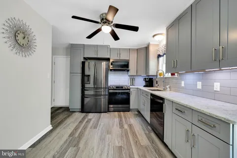 a kitchen with stainless steel appliances granite countertop a stove a refrigerator and a sink