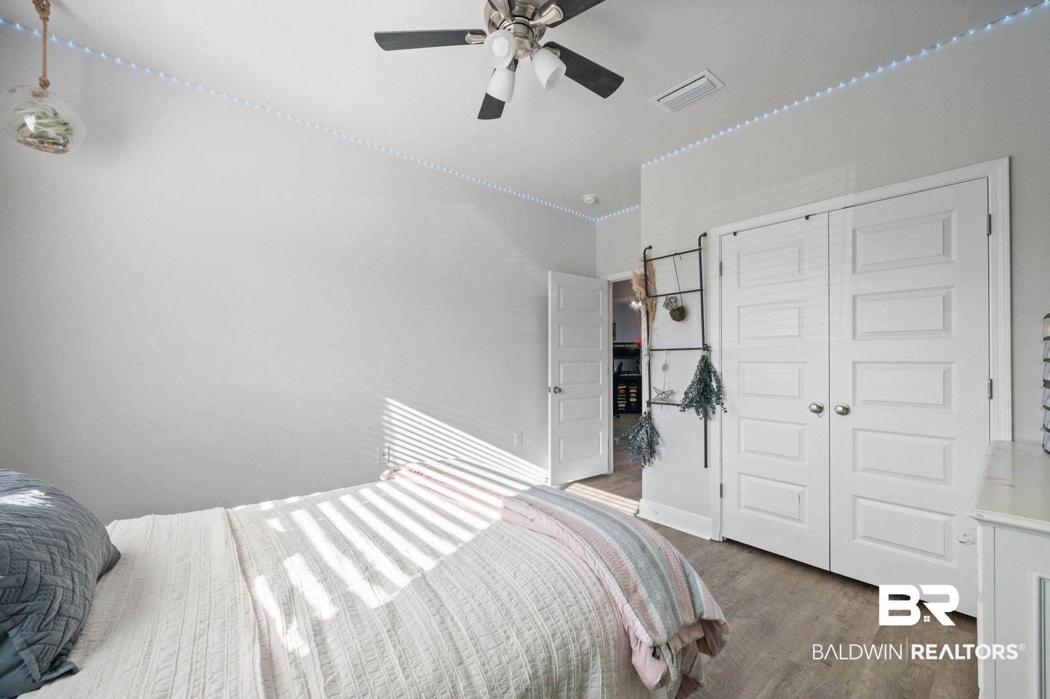 24891 Spectacular Bid Loop Daphne, AL 36526 - Photo 39 of 51 Bedroom featuring ceiling fan, light hardwood / wood-style floors, and a closet