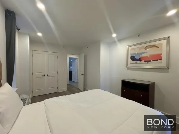 a bedroom with a bed and a painting on the wall