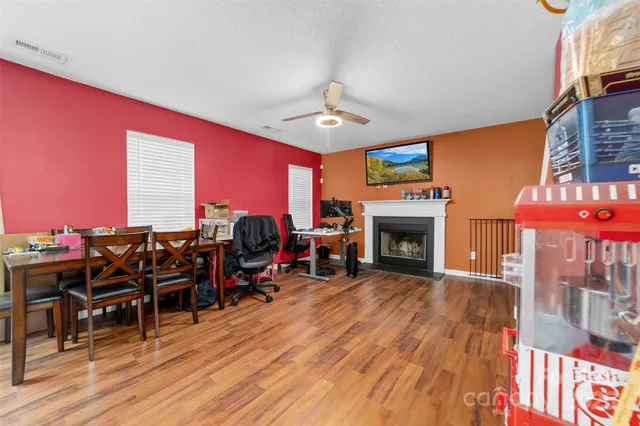 a living room with furniture a fireplace and wooden floor