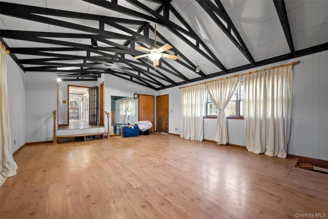 a view of an empty room with wooden floor and staircase