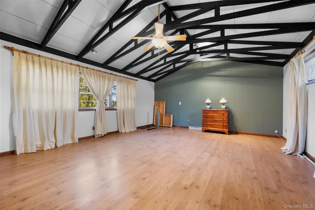 a view of an empty room with wooden floor and stairs