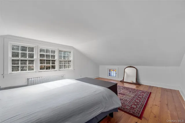 a bedroom with a bed and a large window