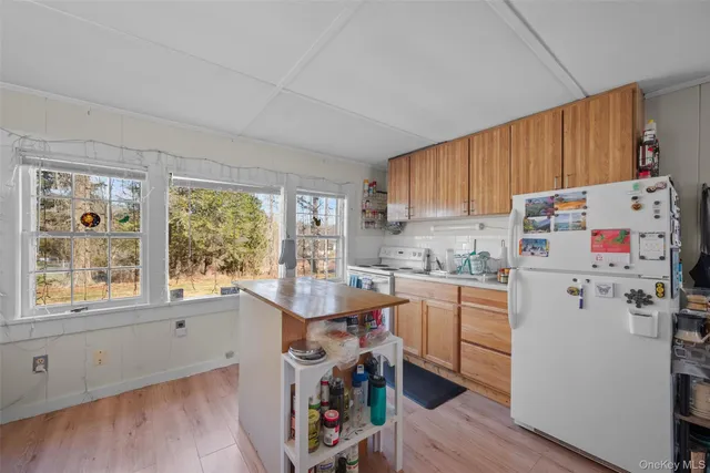 a kitchen with a refrigerator a stove a sink dishwasher and wooden cabinets