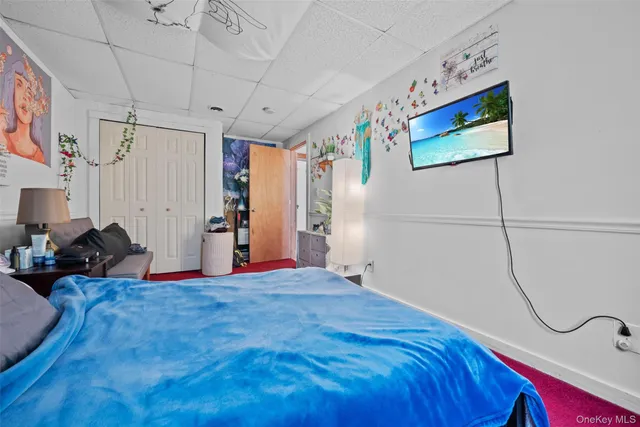 a bedroom with a bed and paintings on the wall