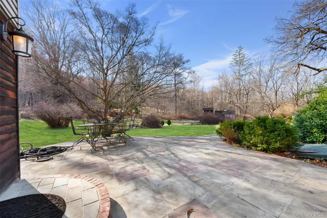 a backyard of a house with plants and large tree