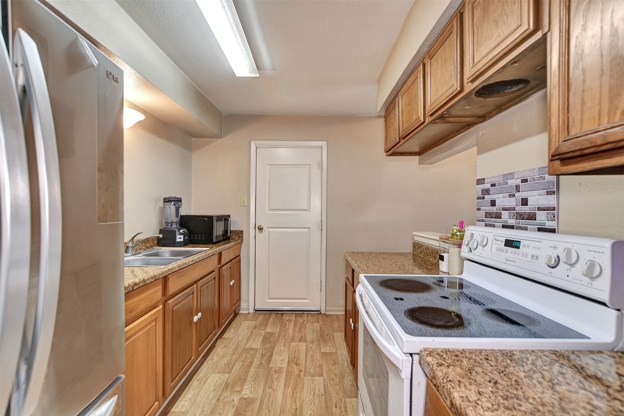 1920 6th Street Hempstead, TX 77445 - Photo 13 of 29 Functional kitchen layout with direct access to additional storage and utility areas, offering convenience and practicality.