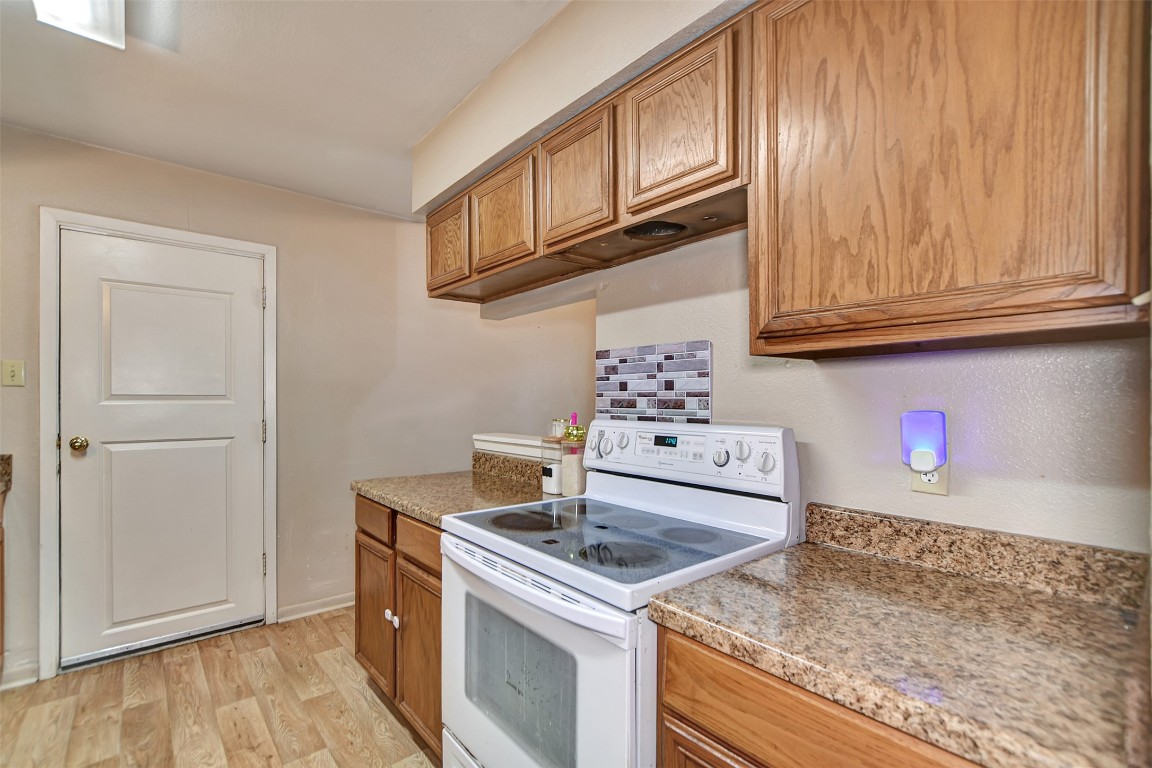 1920 6th Street Hempstead, TX 77445 - Photo 14 of 29 a kitchen with granite countertop a sink stove and cabinets