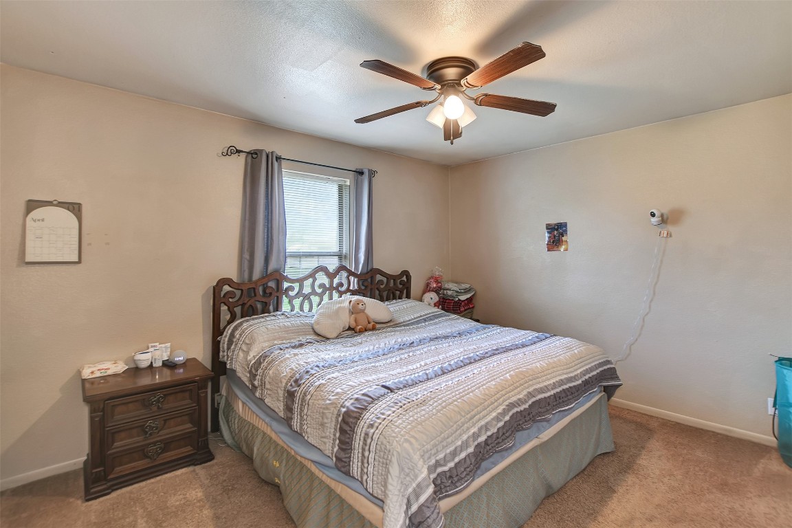 1920 6th Street Hempstead, TX 77445 - Photo 16 of 29 a bedroom with a bed and a chandelier