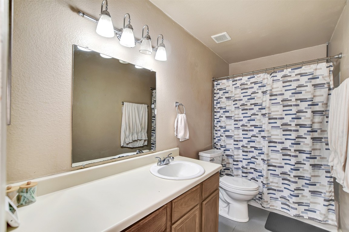 1920 6th Street Hempstead, TX 77445 - Photo 21 of 29 a bathroom with a sink a toilet and shower curtain