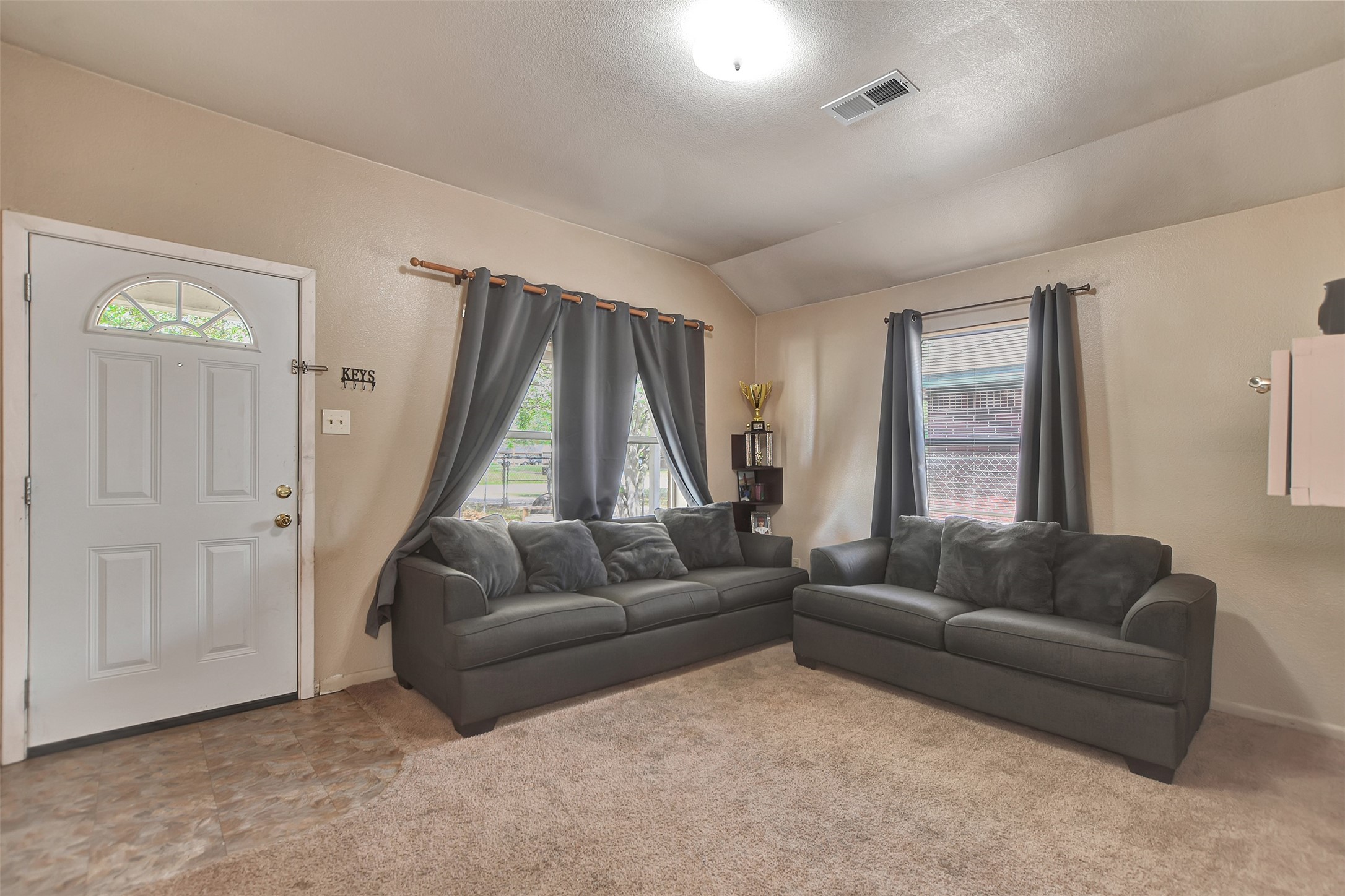 1920 6th Street Hempstead, TX 77445 - Photo 5 of 29 Step inside to an inviting, open living area filled with natural light from large windows, creating a bright and airy atmosphere.