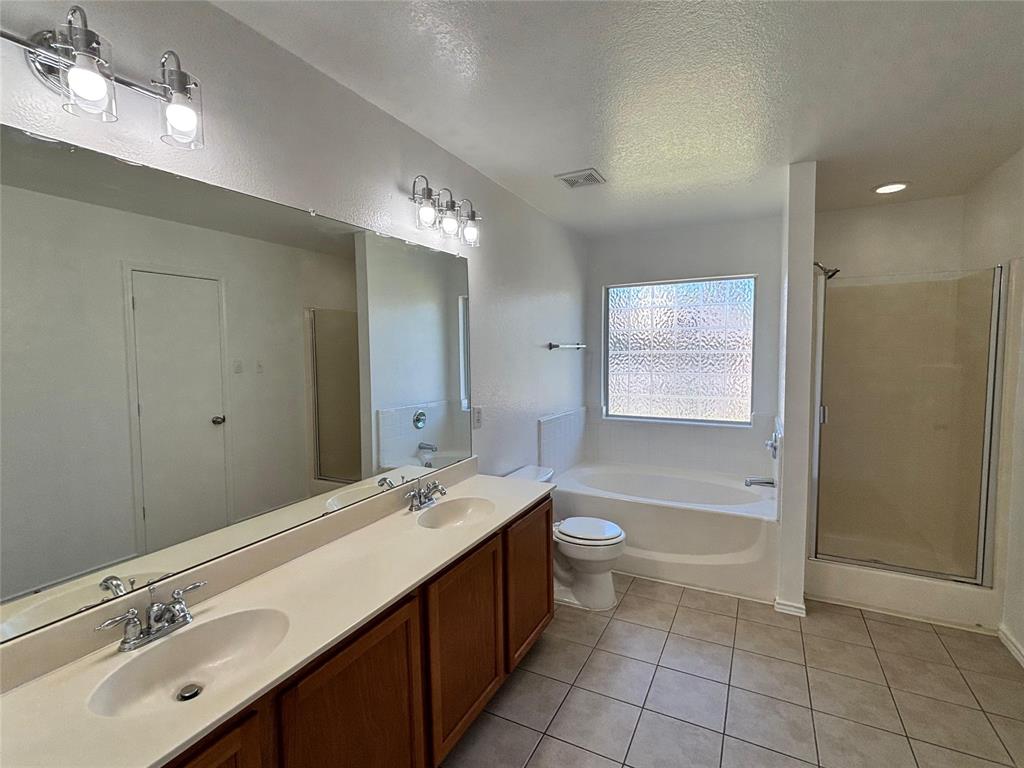 1003 Windsor Lane Forney, TX 75126 - Photo 14 of 20 a bathroom with a double vanity sink a mirror and a bathtub