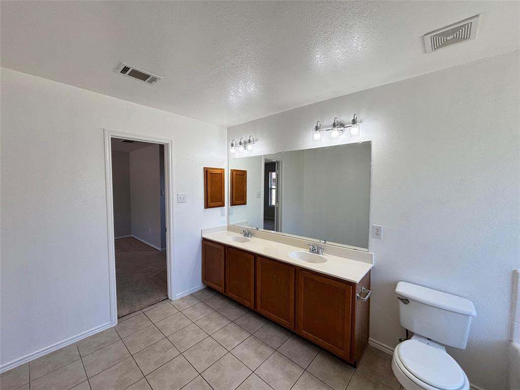 1003 Windsor Lane Forney, TX 75126 - Photo 19 of 20 a bathroom with a toilet sink and mirror
